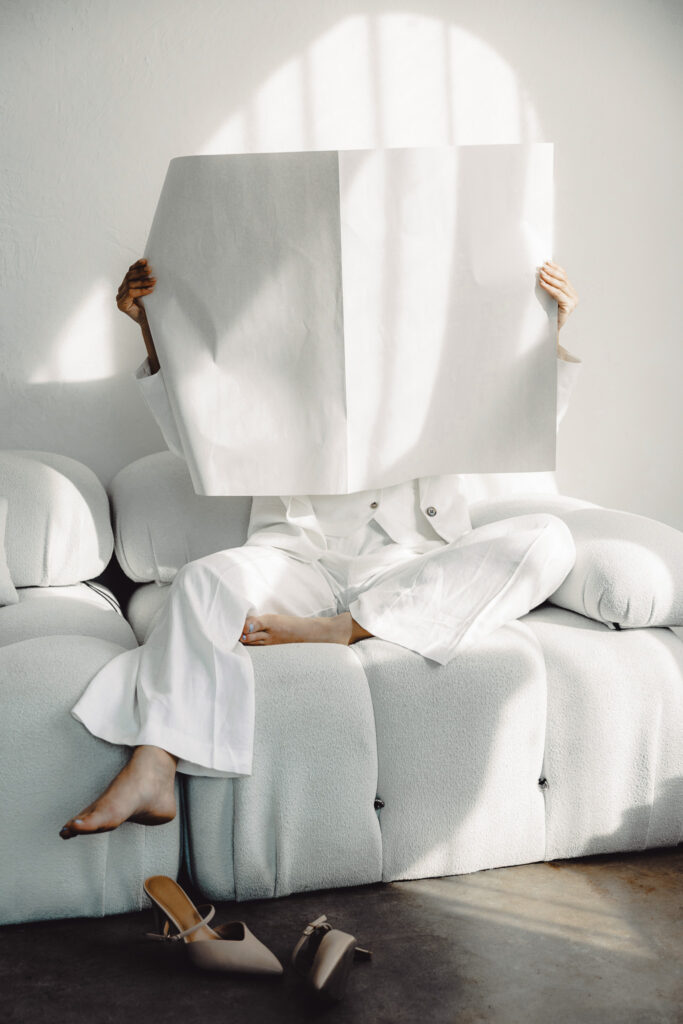 Entrepreneur relaxing on a modern couch while reviewing business automation systems, symbolizing ease and flow in faith-driven workflows.