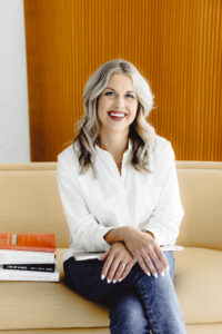 Sarah Klongerbo, smiling confidently in a light, airy setting. She’s the owner of Quotable Copy and a conversion copywriter for creative brands. With a warm, professional presence, she blends strategy and story to help entrepreneurs connect and convert through powerful words.