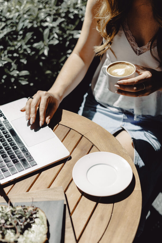 Christian woman entrepreneur storytelling in her business journal at a coffee shop, blending faith and marketing strategy.
