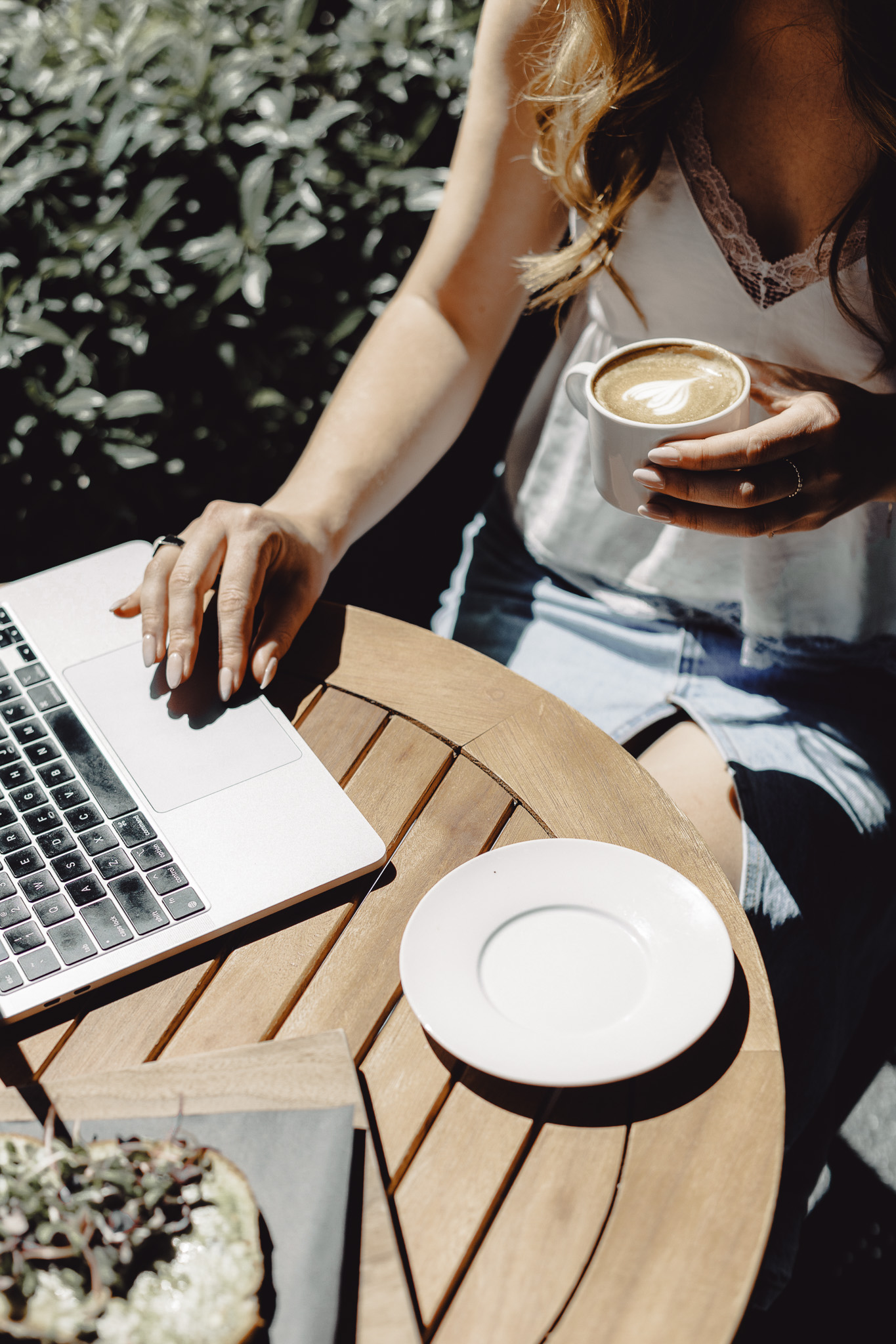 Christian woman entrepreneur storytelling in her business journal at a coffee shop, blending faith and marketing strategy.