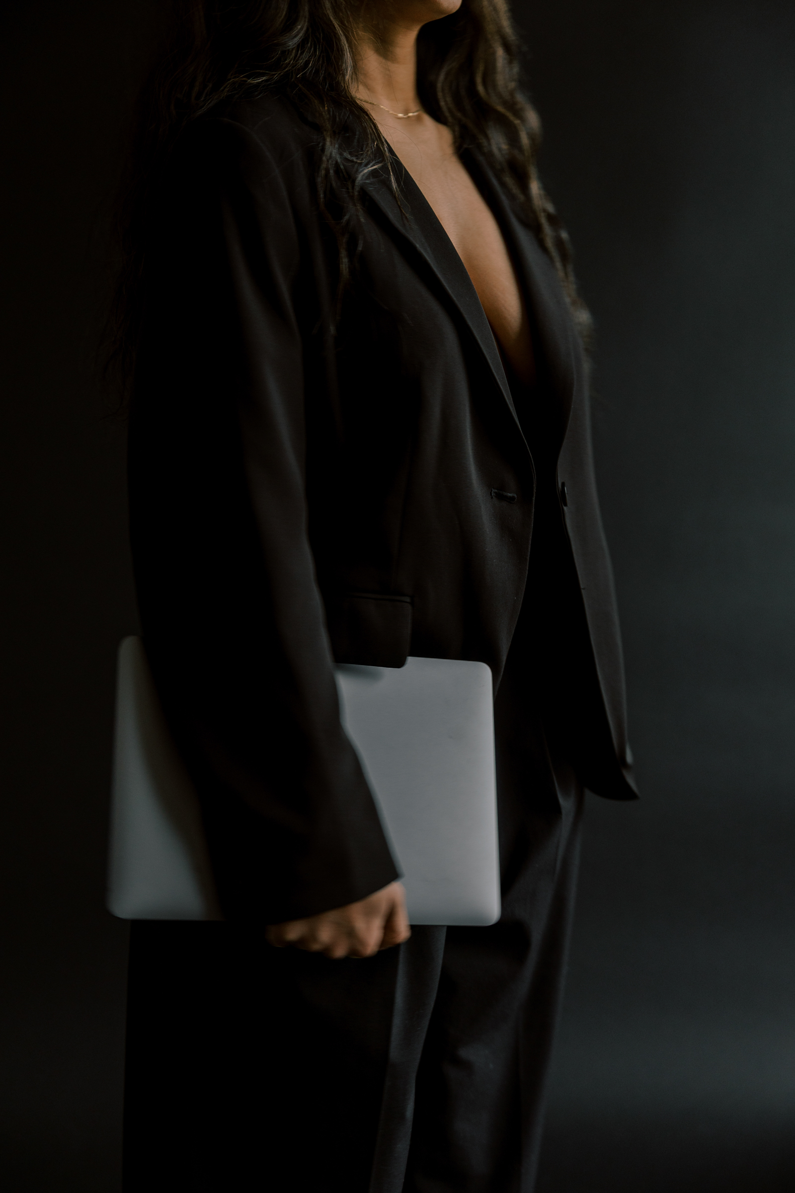 Faith-Driven Woman in Business Suit Holding Laptop