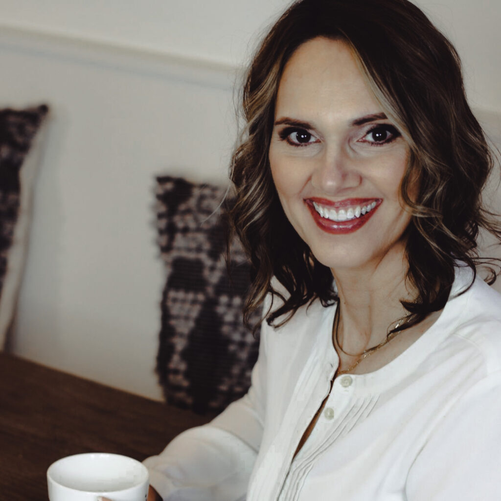 Tracy Hoth smiling at a table with coffee, professional organizer and business coach for Christian entrepreneurs focused on clarity and business growth.