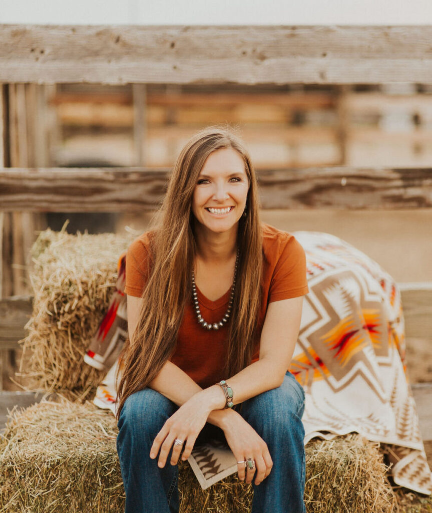 Faith Hanan, SEO strategist and host of Simple SEO Marketing podcast, sitting on hay bales at a ranch